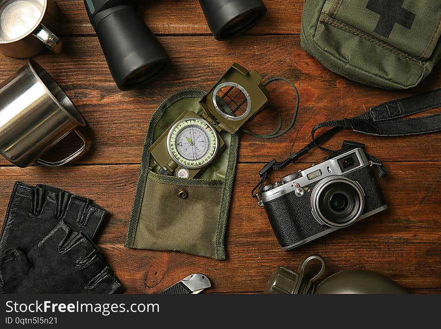 Flat lay composition with camping equipment on wooden background