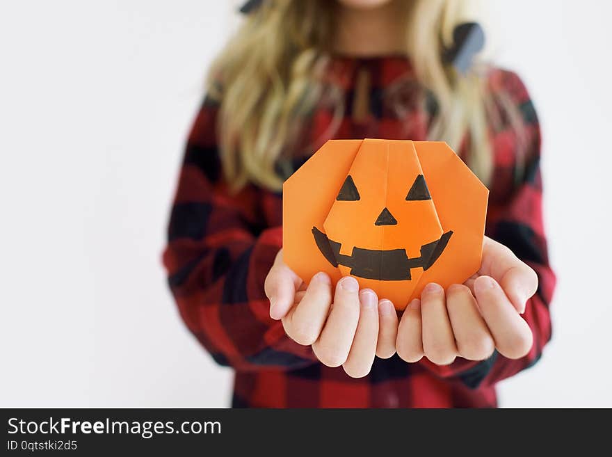 Paper pumpkin origami in the hands of a child