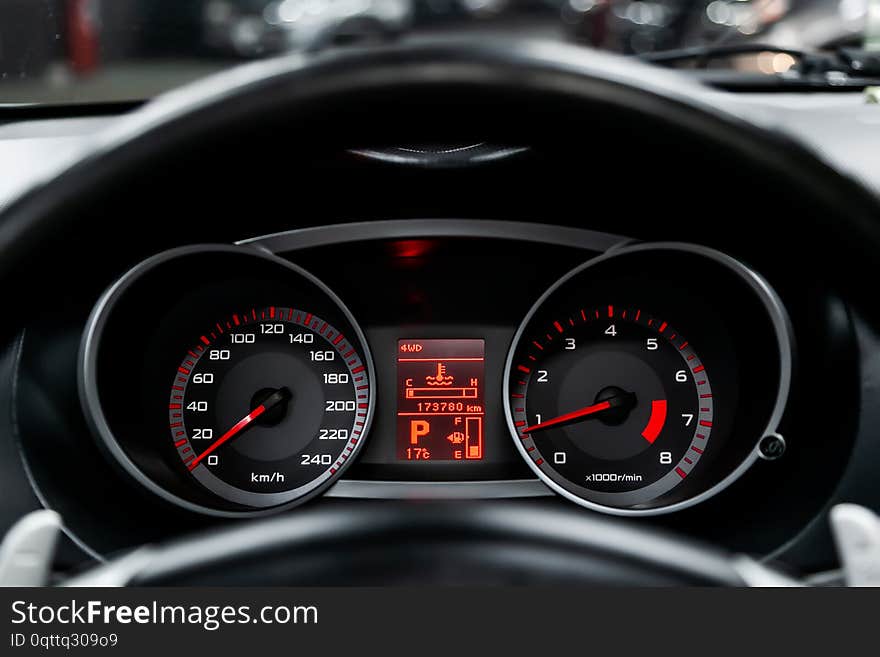 Car dashboard wuth red backlight: Odometer, speedometer, tachometer, fuel level, water temperature and more