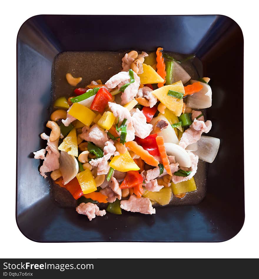 Slices of pork with vegetables and cashew nuts in sweet and sour sauce. Thai dish isolated on white.