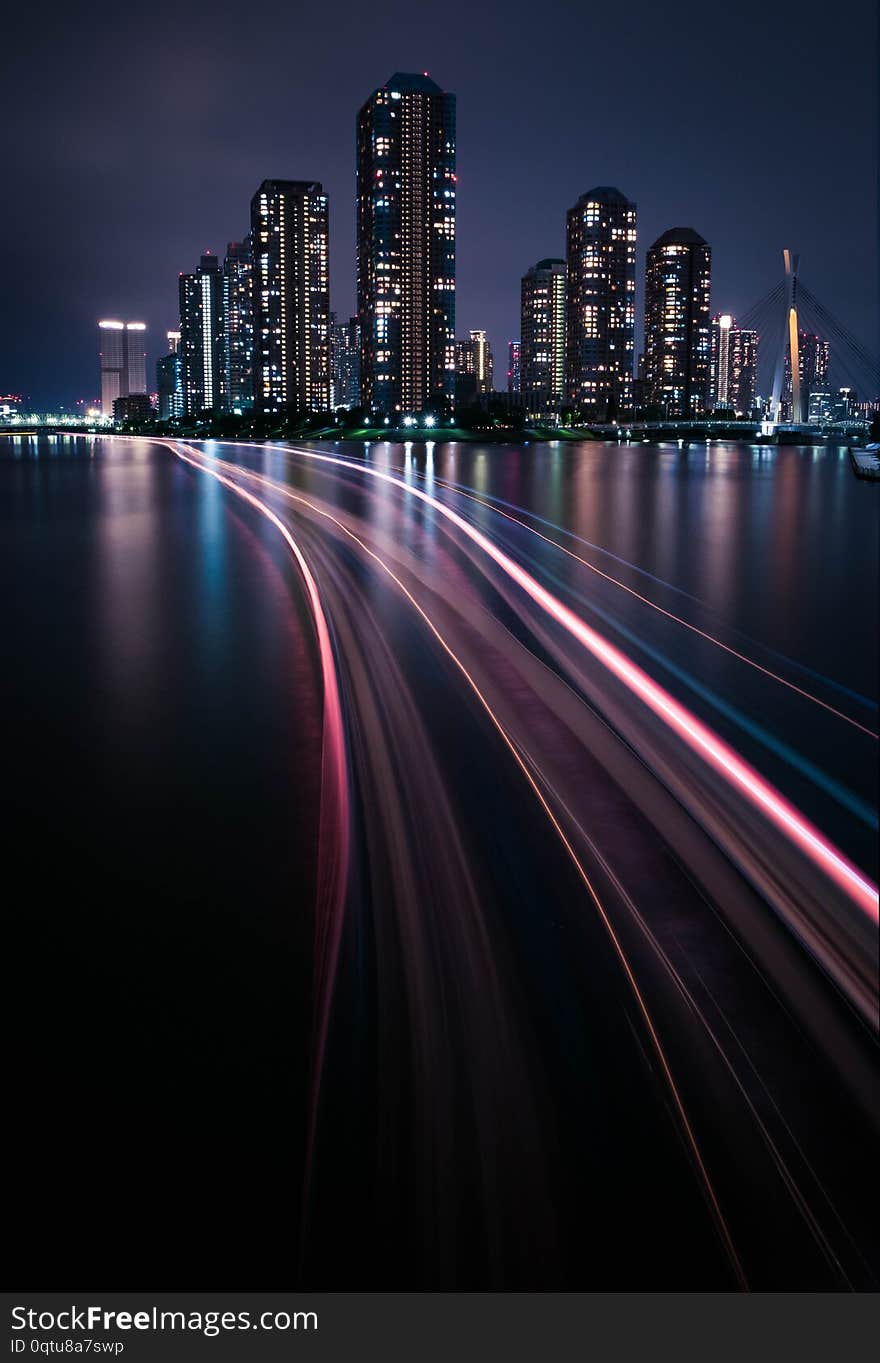 Night view of the luxury condominium in Tokyo next to the river with light trail from the boat. Portrait Orientation. Long