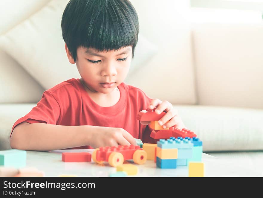 Boy stacking Toy blocks on a living room table