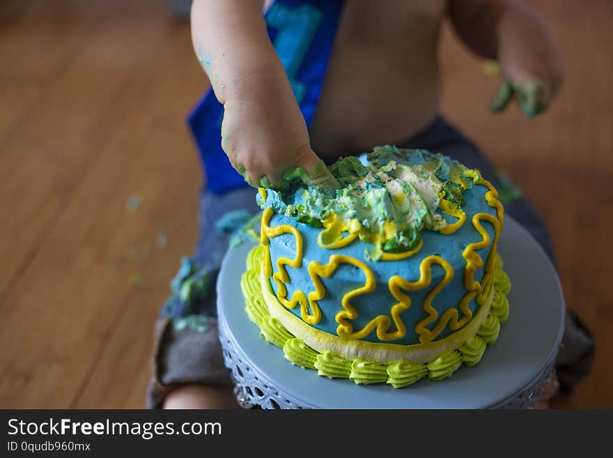 One year old boy putting his fingers into his birthday cake. One year old boy putting his fingers into his birthday cake.