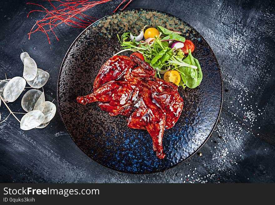 Top view on Chicken tabaka, grilled chicken. Traditional Georgian cuisine. pan-fried chicken served on dark plate. Food photo background for menu. Copy space. Flat lay