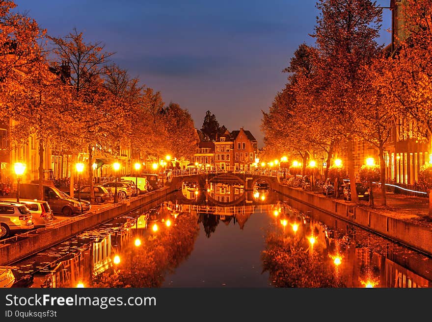 Beautiful autumn night scene in Leiden, The Netherlands still reflections in the canal water. Beautiful autumn night scene in Leiden, The Netherlands still reflections in the canal water