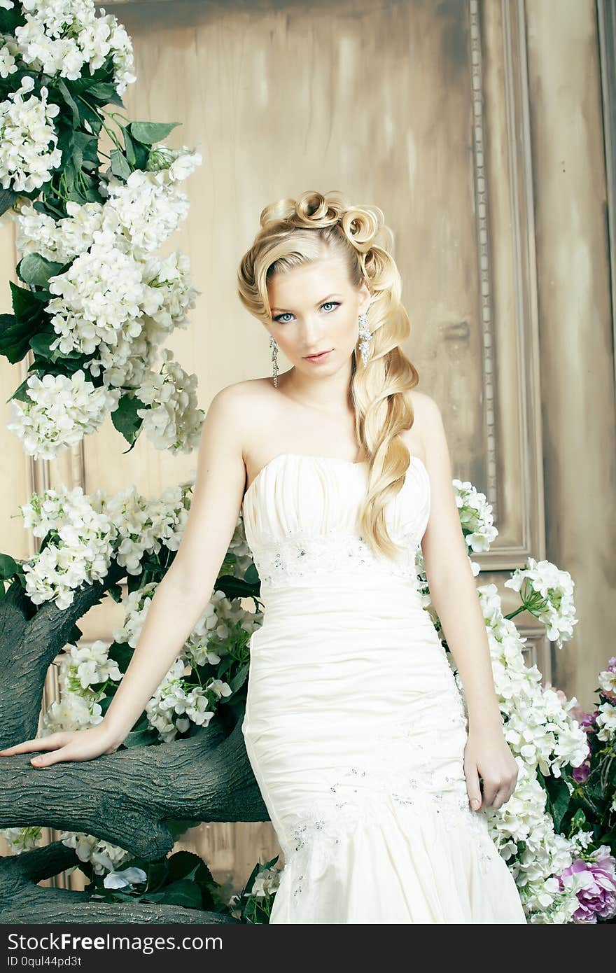 Beauty young bride alone in luxury vintage interior with a lot of flowers, makeup and creative hairstyle closeup