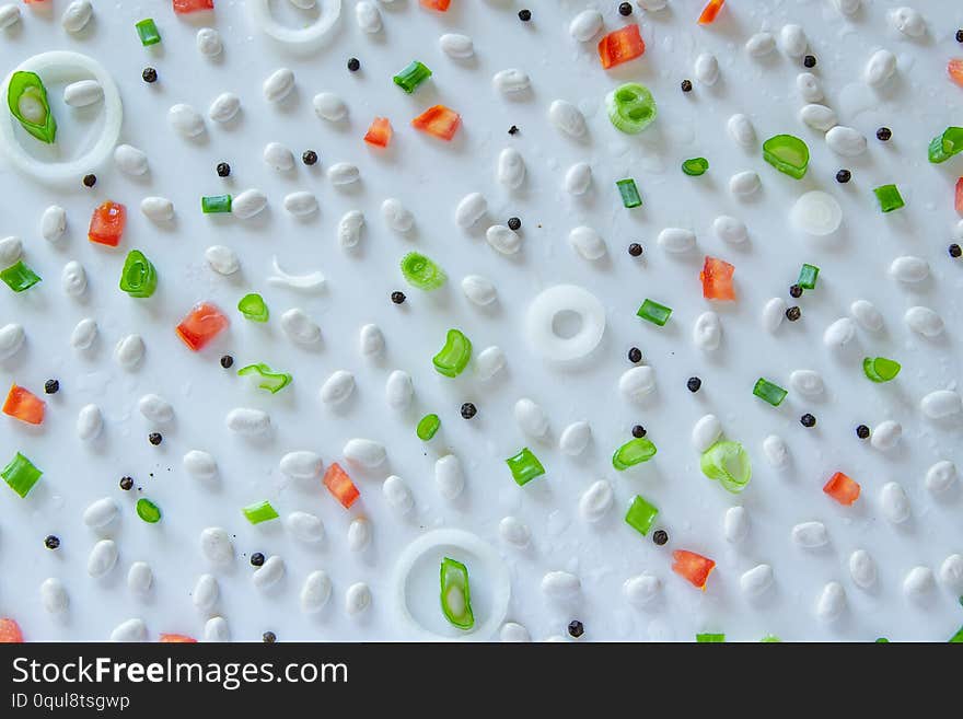 Food pattern with beans, onion, tomatoes, salt and pepper on white background