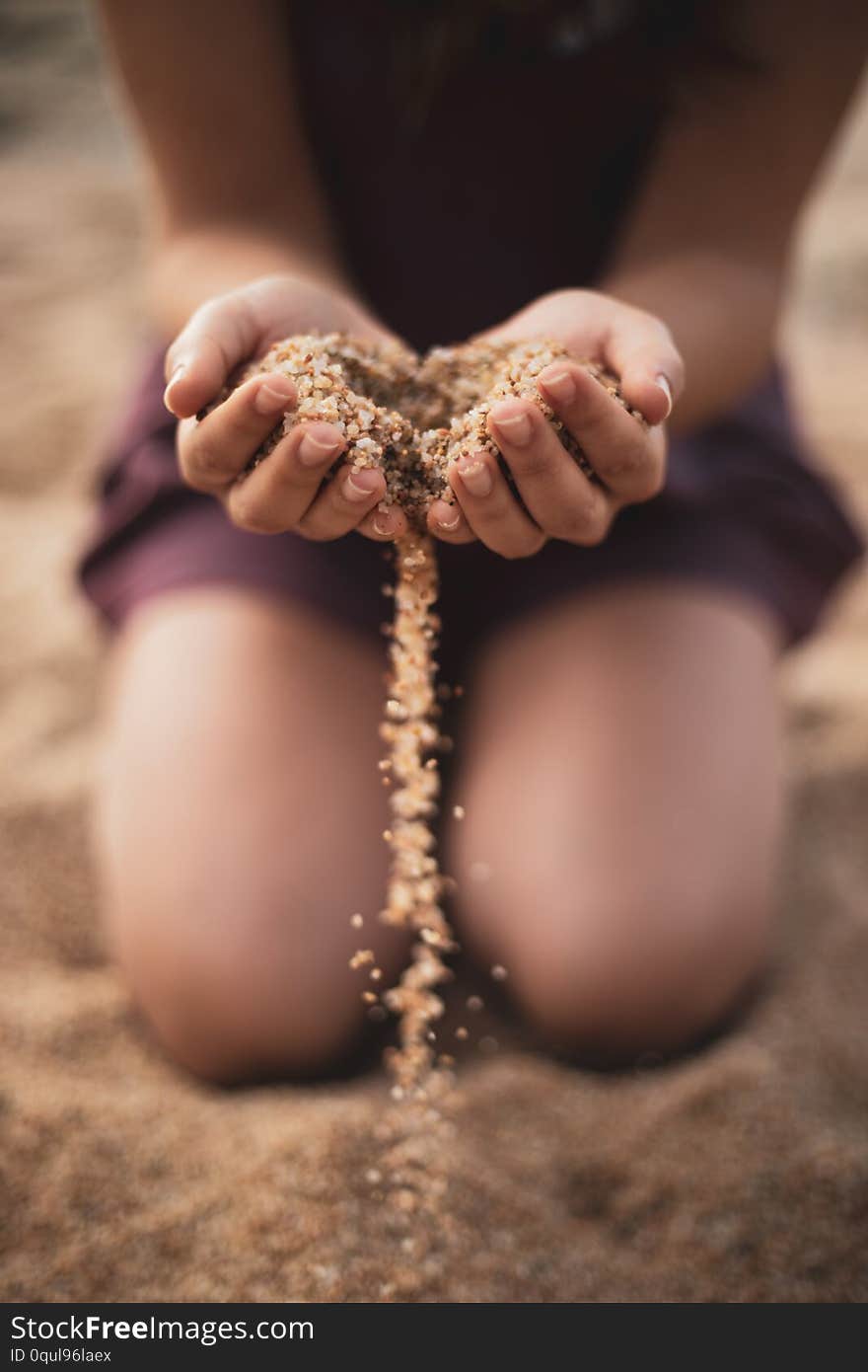 Dropping sand from both hands of woman closeup shot movement