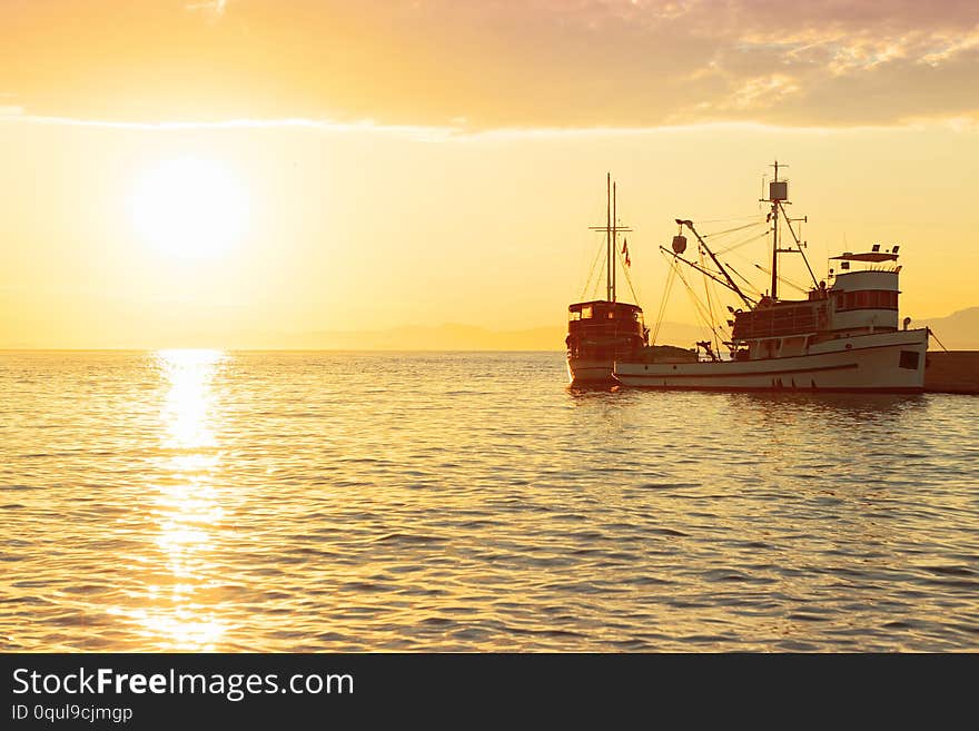 Fishing trawler at sunrise moored in the beautiful harbor of a small town Postira - Croatia, island Brac