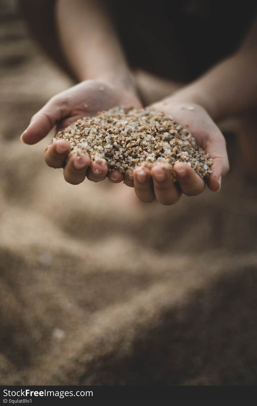 Dropping sand from both hands of woman