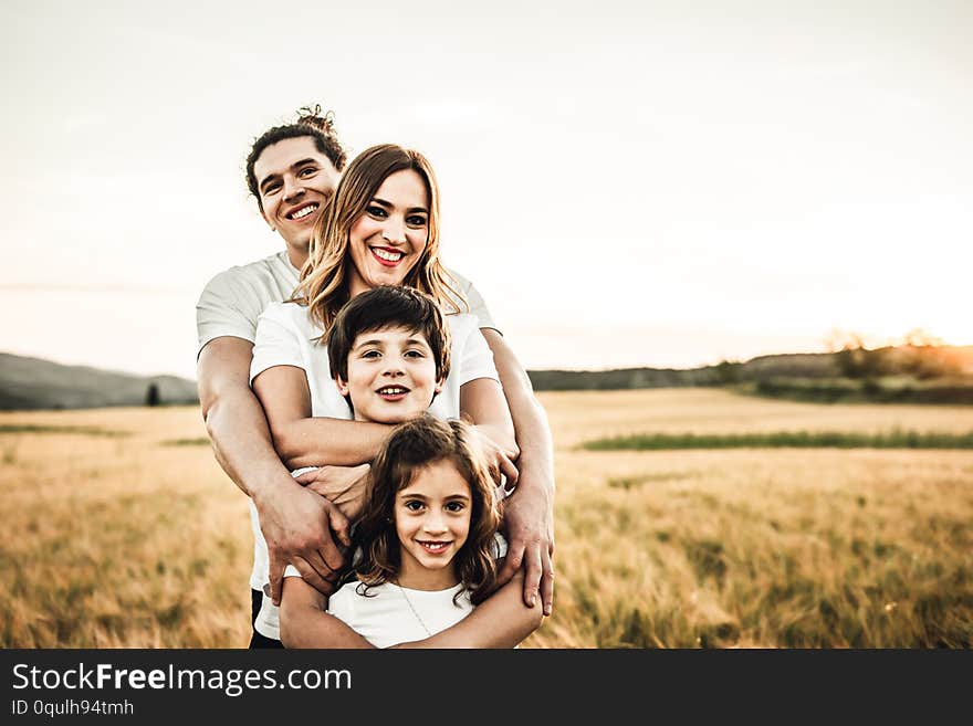 Portrait of a happy young family smiling in the countryside. Concept of family fun in nature