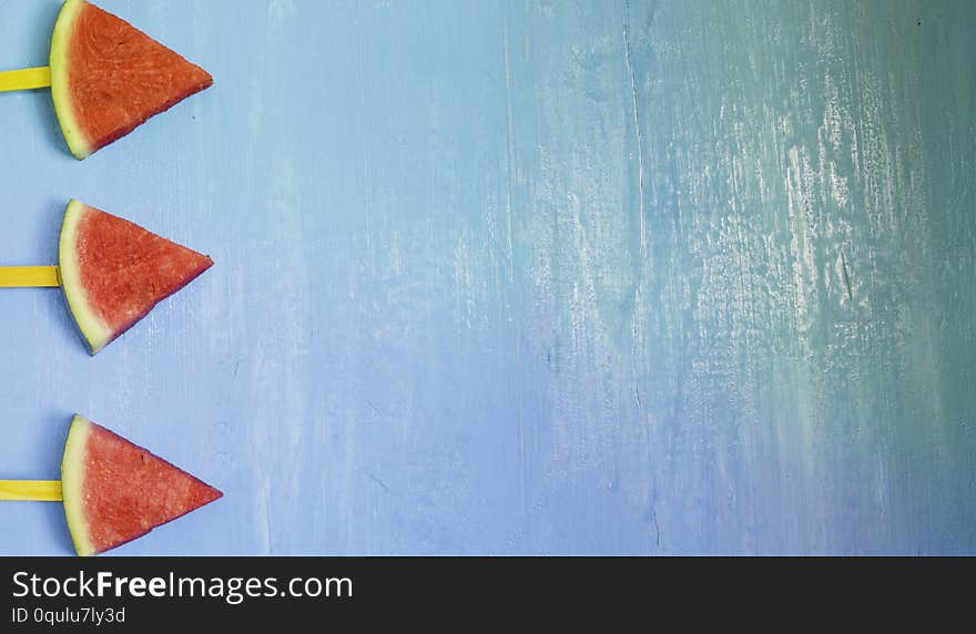 Top view, flat lay, skewers of watermelon slices and mint on bright blue wood background,concept organic fruit  non-toxic for health,for refreshing and fun in summer with copy space