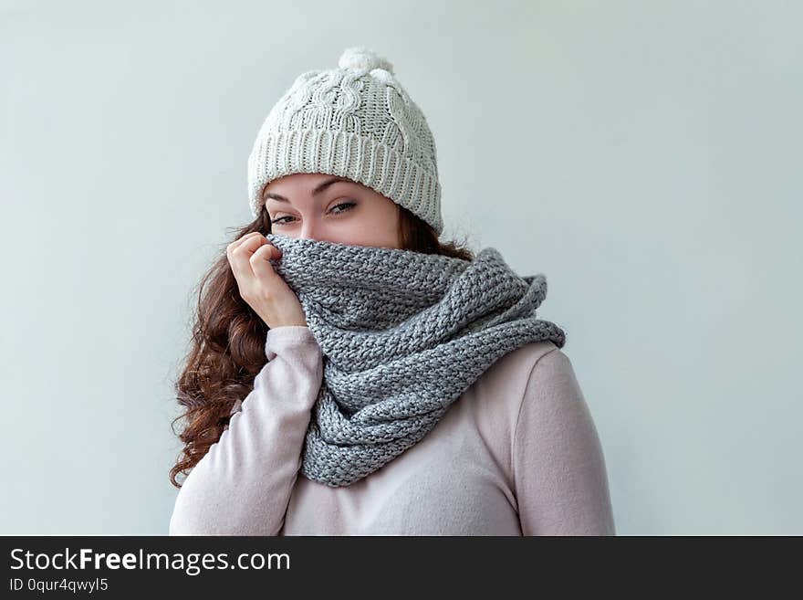 Laughing girl wearing warm clothes hat and scarf isolated on white background