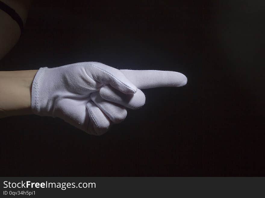 Gesture. Hand in white glove pointing, isolated on black. Gesture. Hand in white glove pointing, isolated on black