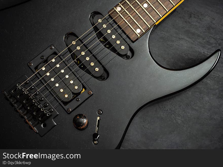 Black electric guitar on black cement floor. Top view and copy space for text. Concept of rock music