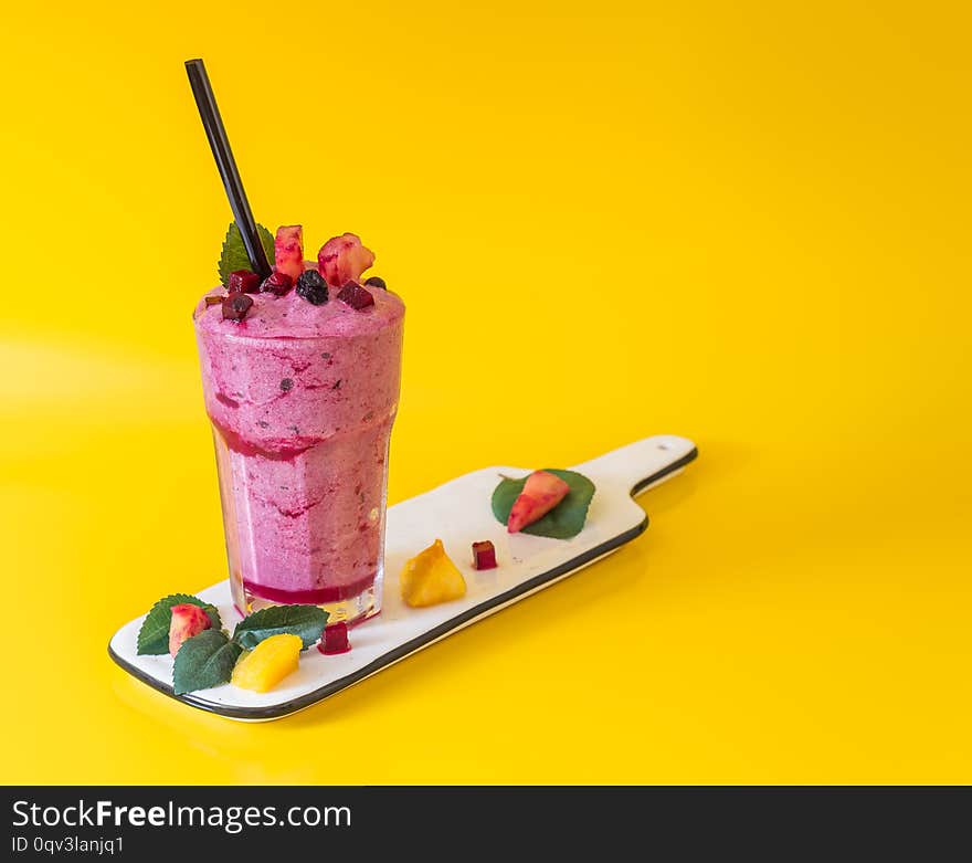 Homemade smoothie with fresh blueberries on a orange background