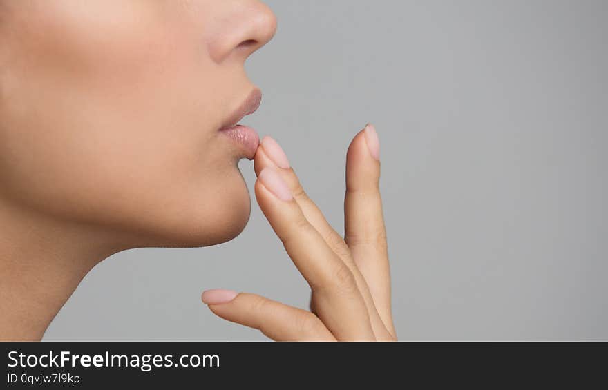 Lip Protection. Woman Applying Balm, Touching Lips over Grey Background, Side View