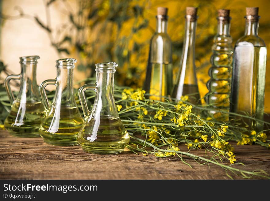 Rapeseed Flowers And Rapeseed Oil In A Bottle On The Table