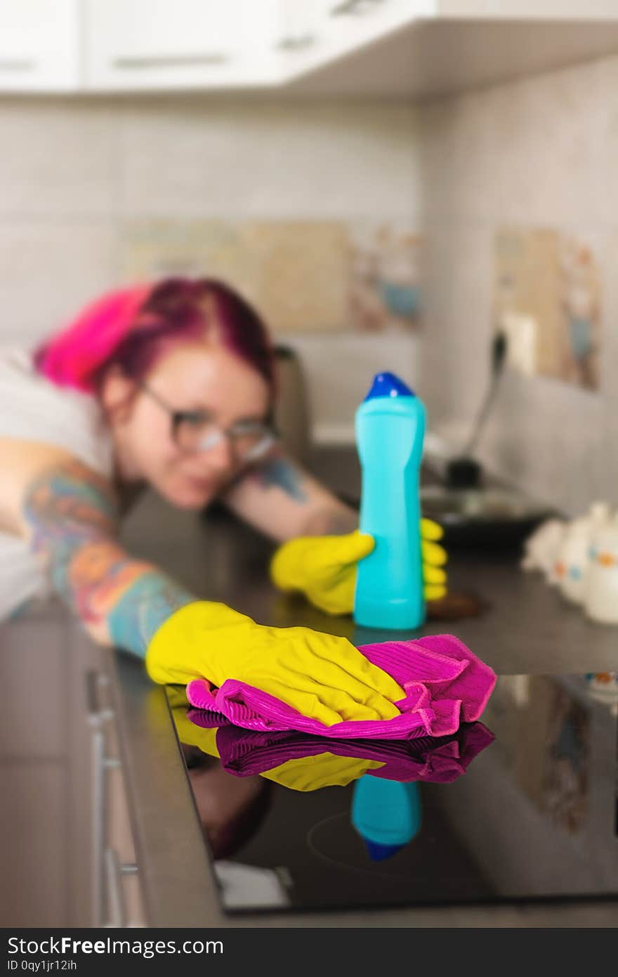 Woman in protective gloves wiping dust using cleaning spray and duster. Cleaning service concept.