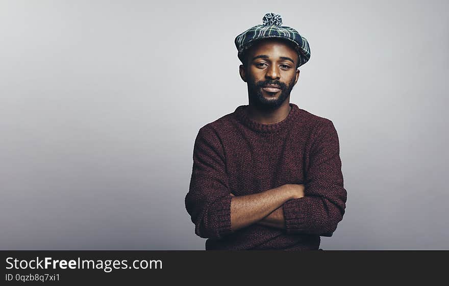 Man in scottish cap isolated on grey background. African american man looking at camera with arms crossed. Man in scottish cap isolated on grey background. African american man looking at camera with arms crossed