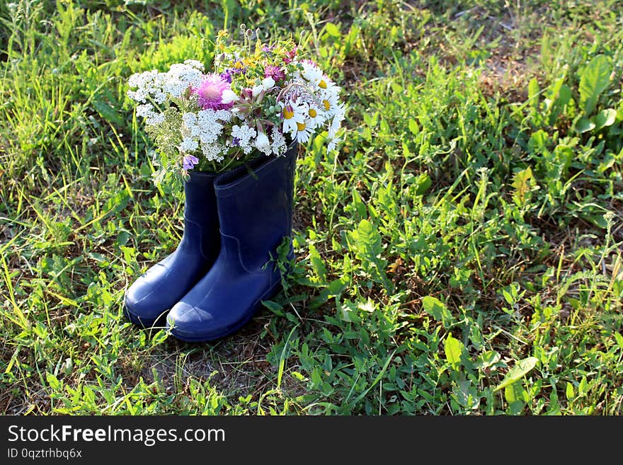 A bouquet of spring wild flowers standing in a rubber boot