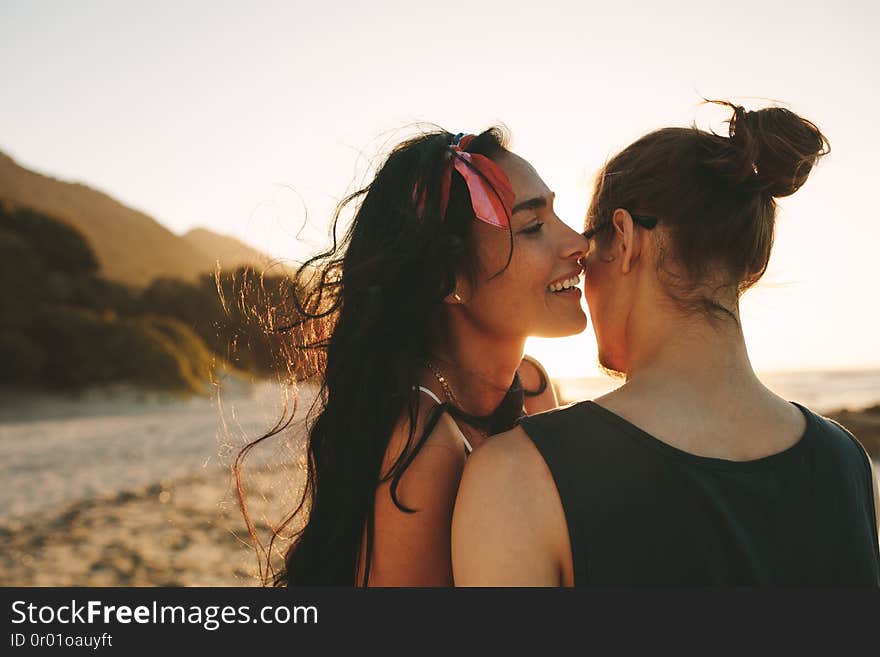 Woman whispering loving words in ear on her boyfriend. Beautiful couple spending time together on their summer vacation. Woman whispering loving words in ear on her boyfriend. Beautiful couple spending time together on their summer vacation