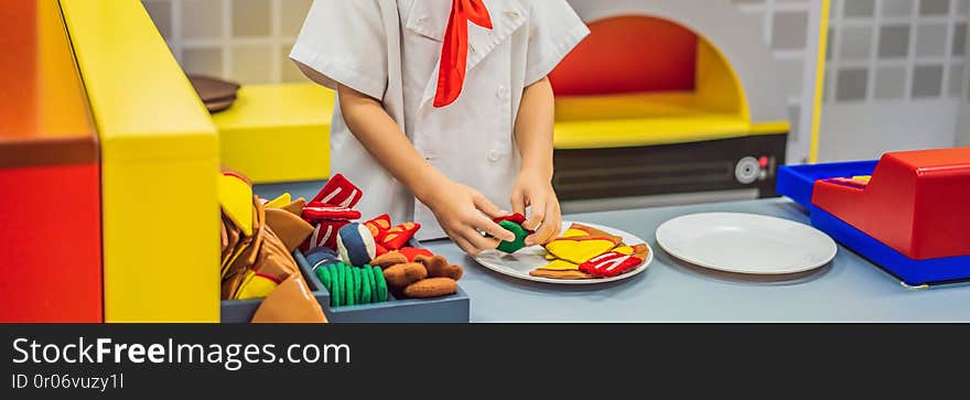 The boy plays in the toy kitchen, cooks a pizza BANNER, LONG FORMAT