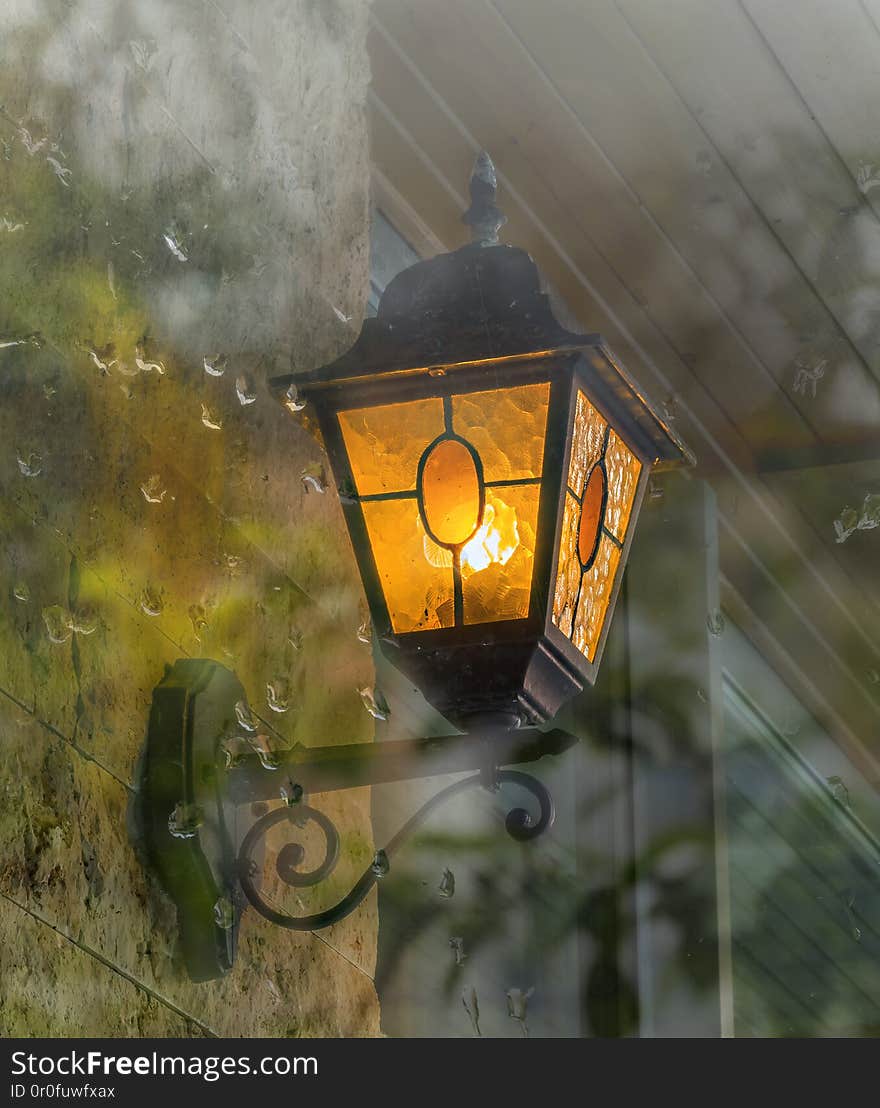 Decorative street lamp seen through window glass, old European provincial town, selective . Decorative street lamp seen through window glass, old European provincial town, selective