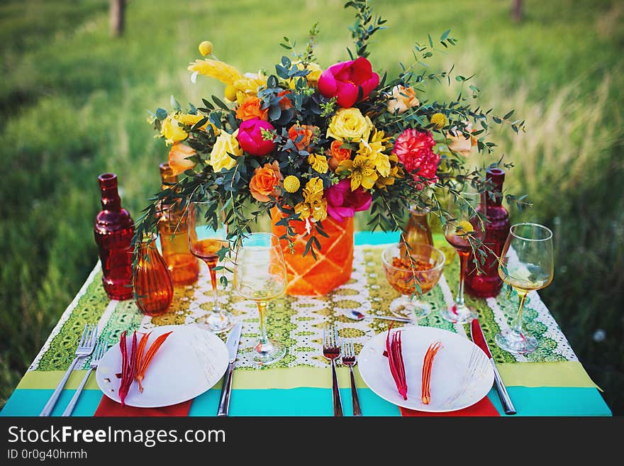 Beautiful outdoor dinner picnic in the nature with fresh flowers on the table. Beautiful outdoor dinner picnic in the nature with fresh flowers on the table.