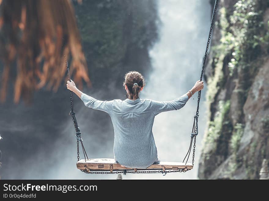 Beautiful woman swings near waterfall in the jungle of Bali island, Indonesia.