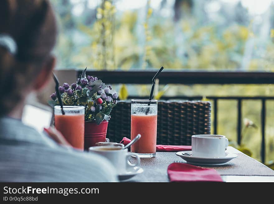 Young woman drinking a cup of coffee in the morning with the jungle view during luxury vacation in Bali island. Indonesia.