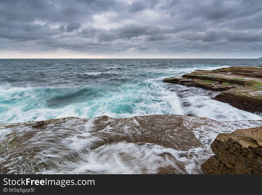 Stormy ocean in Sydney with gray heavy clouds and unsert sea with white foam and cyan color. antongorlin.com. Stormy ocean in Sydney with gray heavy clouds and unsert sea with white foam and cyan color. antongorlin.com