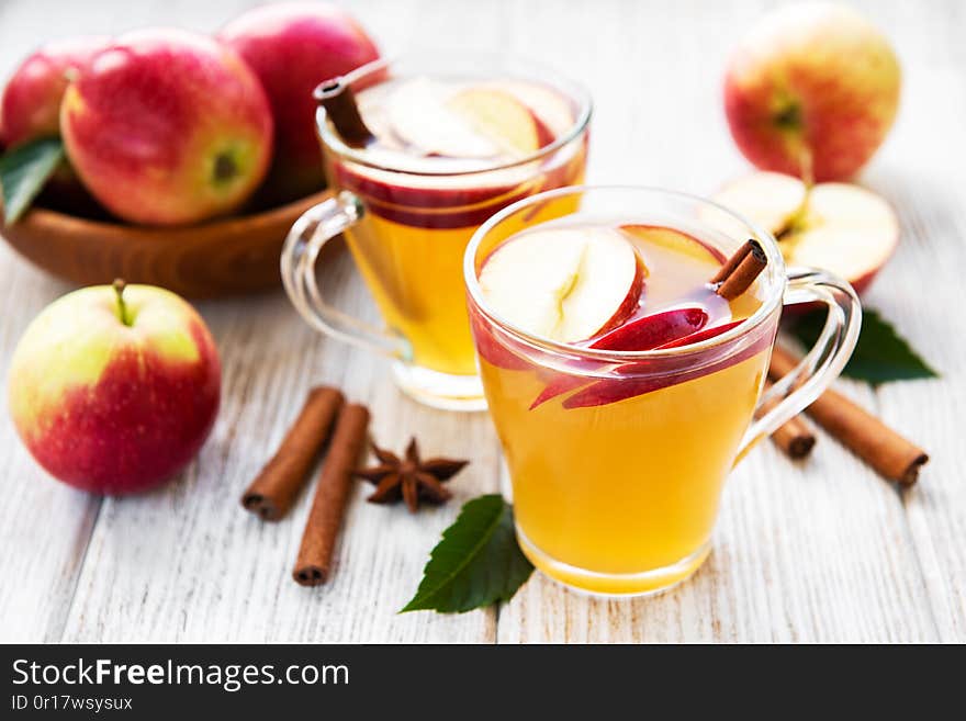 Apple cider with cinnamon sticks on a old wooden table. Apple cider with cinnamon sticks on a old wooden table