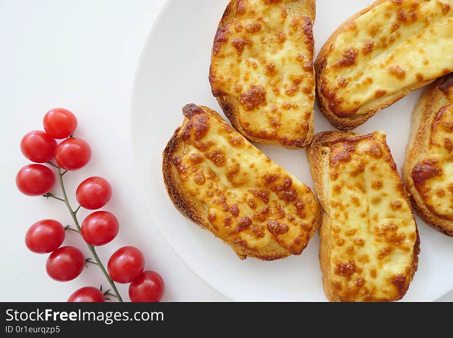 Roasted Cheese Toasts And Cherry Tmatoes In A White Plate