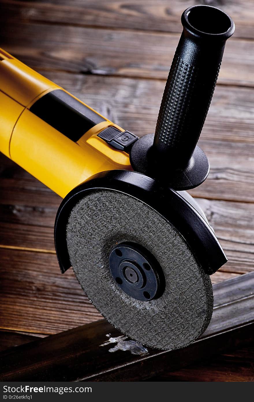 corner electric grinder with stone for metal lies on a dark background close-up. corner electric grinder with stone for metal lies on a dark background close-up