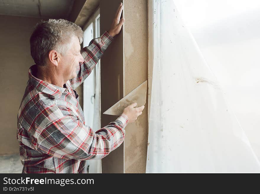 Diligent plasterer man or worker working on a window opening. Diligent plasterer man or worker working on a window opening