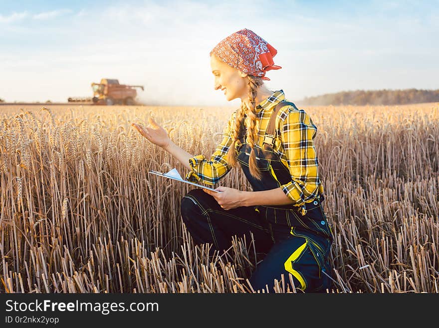 Farmer on a field during harvest with clipboard doing controlling