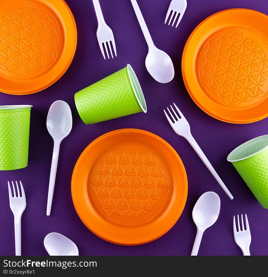 Plastic orange green waste collection on purple background. Concept of plastic pollution and ecology problem