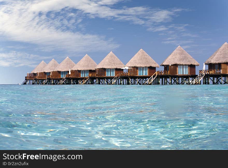 Houses over transparent quiet sea water- tropical paradise, Maldives.
