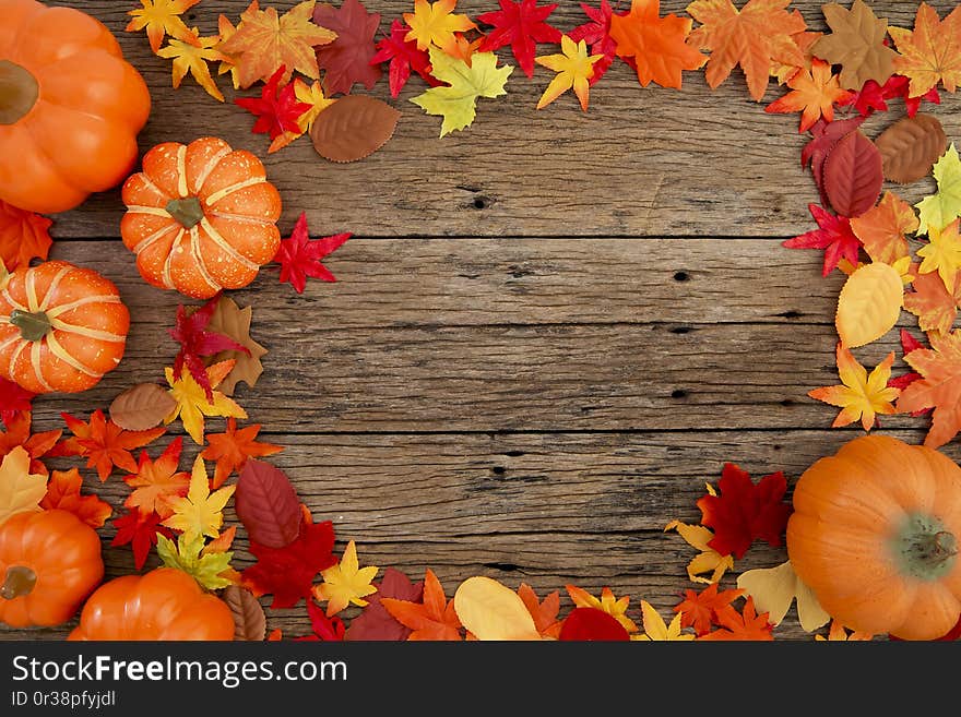 Autumn multicolored  leaves and pumpkins old brown wood table background with copy space, flat lay, minimal concept. Autumn multicolored  leaves and pumpkins old brown wood table background with copy space, flat lay, minimal concept
