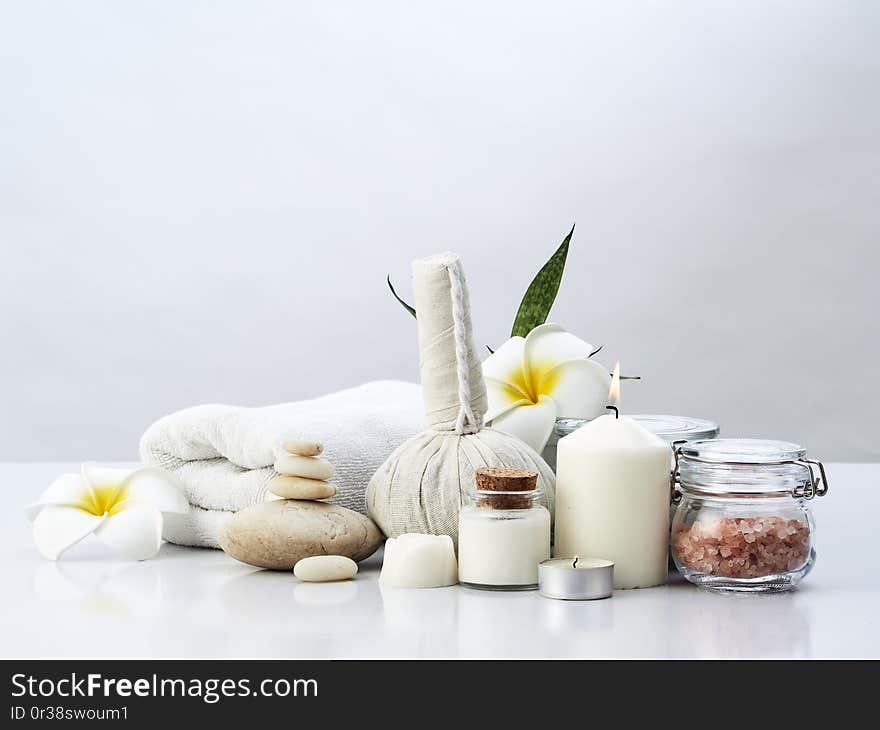 Spa massage concept, herbal compress ball, cream, flower soap, scented candle and Himalayan pink salt, isolated on white. Spa massage concept, herbal compress ball, cream, flower soap, scented candle and Himalayan pink salt, isolated on white