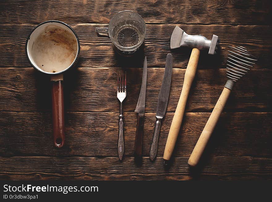 Old kitchen utensils on a rural kitchen table background, dishes, accessories, hammer, cutlery, vintage, retro, wooden, rustic, simple, ladle, knife, fork, glass, cup, top, view, above, flat, flatlay, kitchenware, equipment, tools, shaker, beater, mallet, food, cook, cooking, set, collection. Old kitchen utensils on a rural kitchen table background, dishes, accessories, hammer, cutlery, vintage, retro, wooden, rustic, simple, ladle, knife, fork, glass, cup, top, view, above, flat, flatlay, kitchenware, equipment, tools, shaker, beater, mallet, food, cook, cooking, set, collection