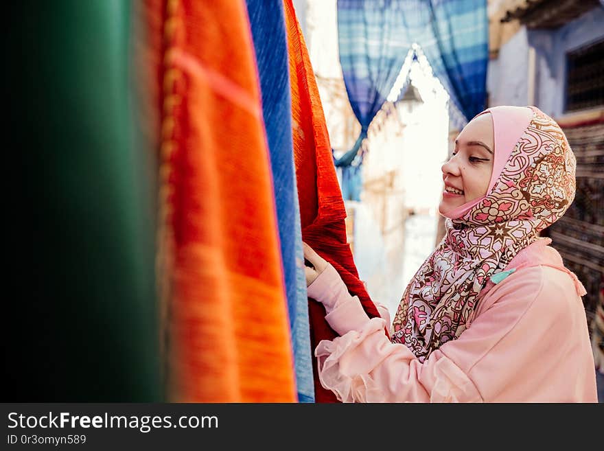 Tourist on a street with carpets - Chefchaouen, Morocco