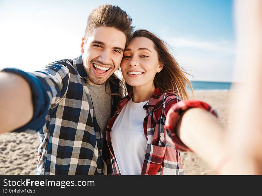 Happy young loving couple outside in free alternative vacation camping take selfie by camera