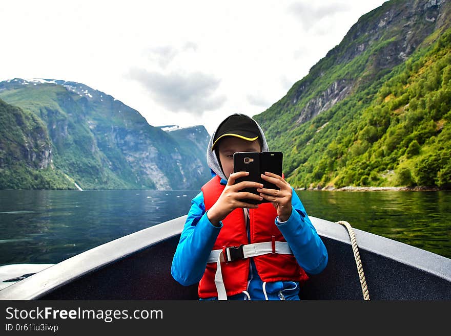 GEIRANGERFJORD, SUNNMORE, NORWAY - JULY 8, 2018. Leisure time and adventure with the motor boat, amazing trip at Geirangerfjord, stunning natural masterpiece, Sunnmore region, Norway