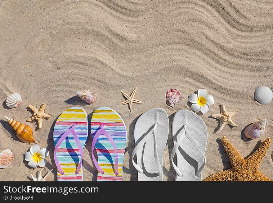 Flat lay composition with flip flops and space for text on sand. Summer beach accessories. Flat lay composition with flip flops and space for text on sand. Summer beach accessories