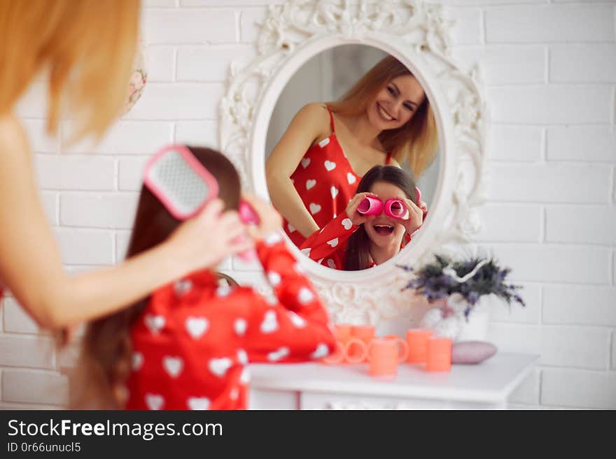 Family at home. Mother with little daughter. Girls in a red pajamas. Family at home. Mother with little daughter. Girls in a red pajamas