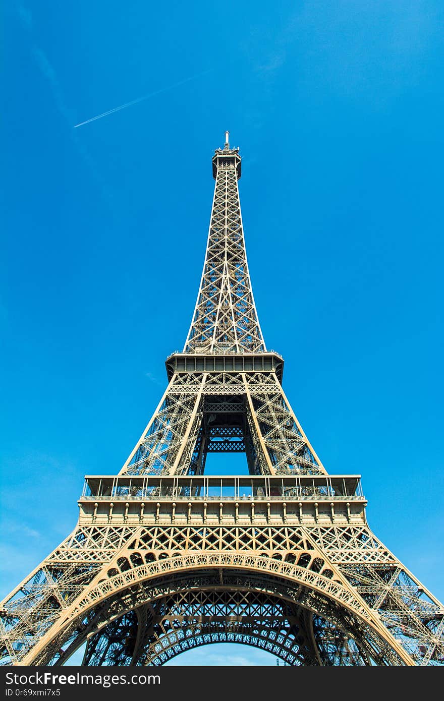 Detailed view of the Eiffel Tower on the background of bright blue sky. Detailed view of the Eiffel Tower on the background of bright blue sky