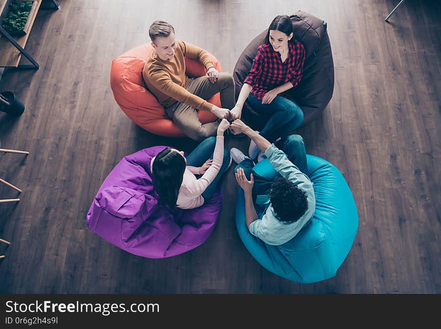 Top above high angle view of nice cheerful guys on bag chair managers, attainment agree agreement holding fists together trust support at industrial wooden loft interior workplace workstation. Top above high angle view of nice cheerful guys on bag chair managers, attainment agree agreement holding fists together trust support at industrial wooden loft interior workplace workstation