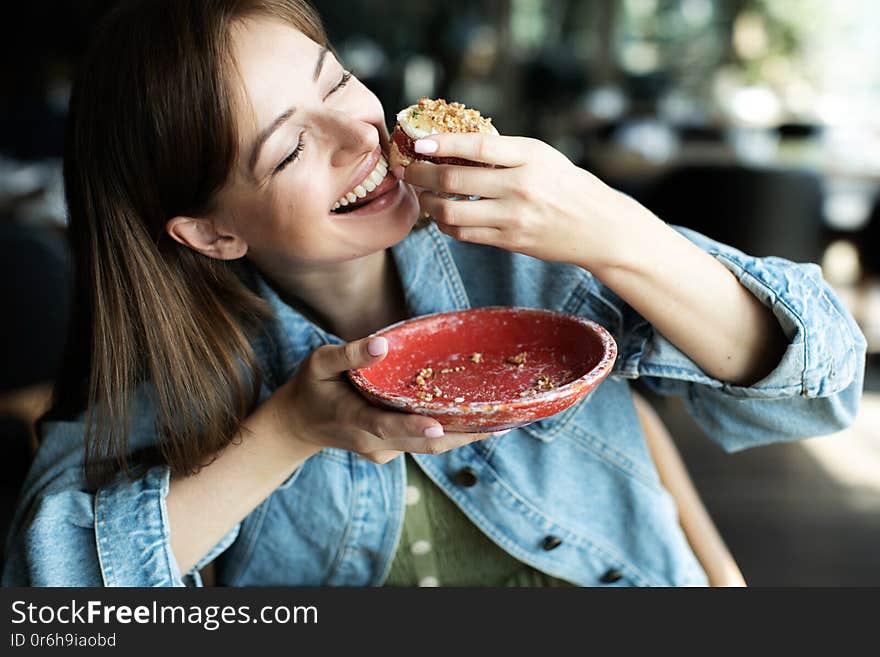 Young girl drinking a tea with dessert in cafe